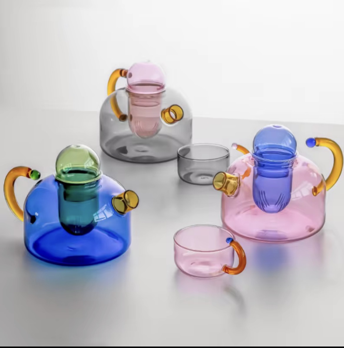 Coloured glass teapots and cups catching the light.