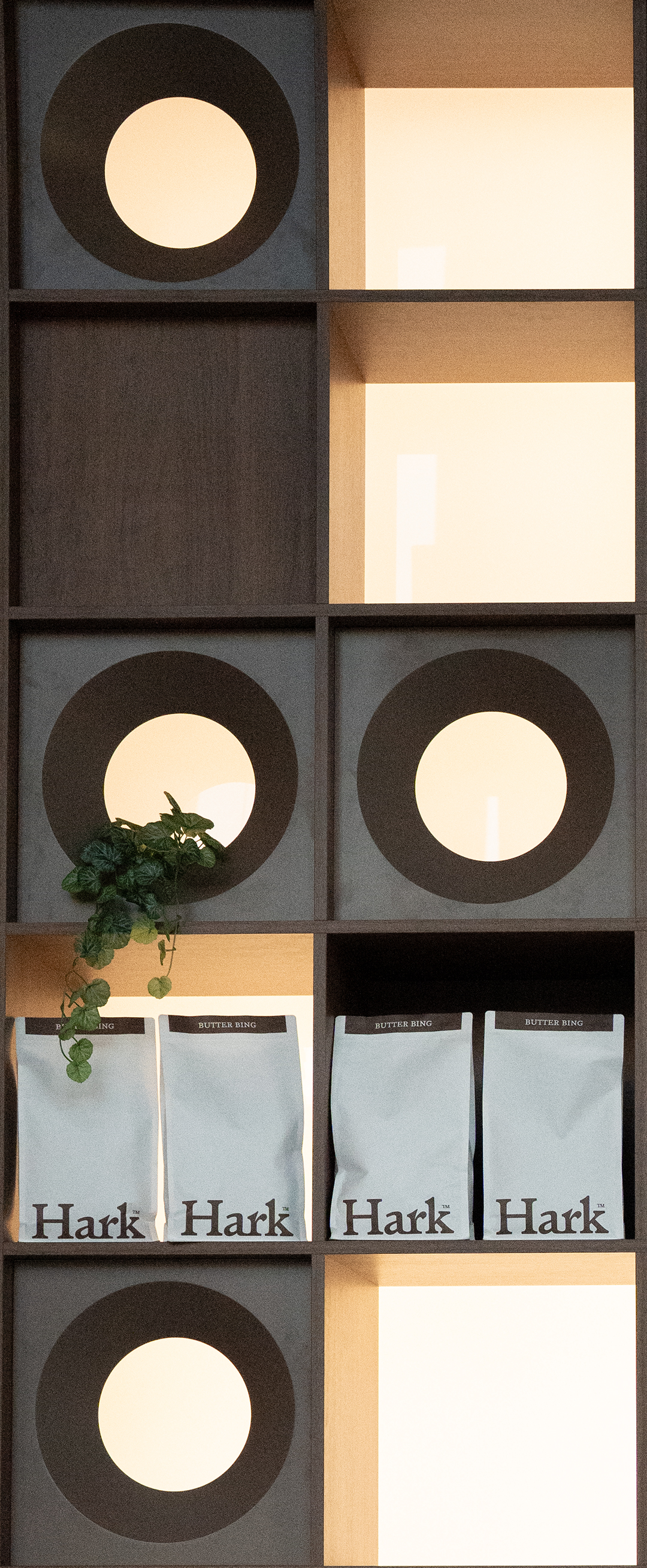 A closer angle along the Hark shelf, bags catching the light.