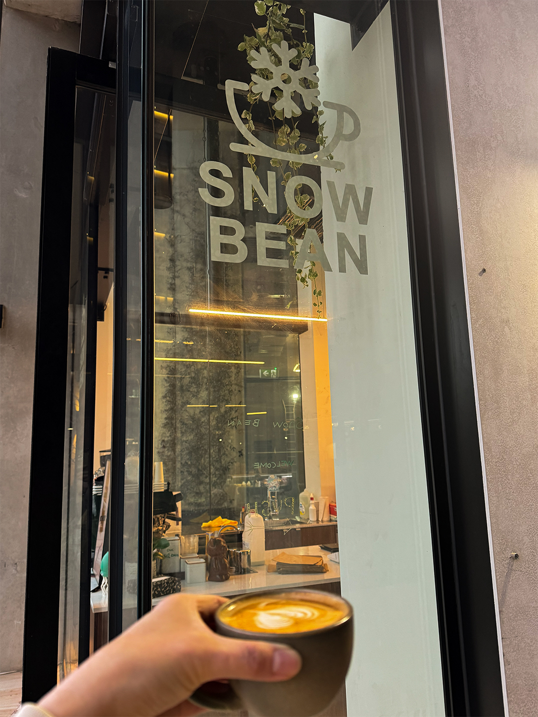 The frosted glass door at Snow Bean, warm light glowing from inside.
